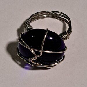 silver wire ring with a large glass / stone in navy blue